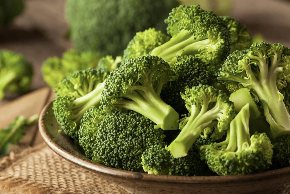 A close up shot of broccoli in a stoneware bowl.