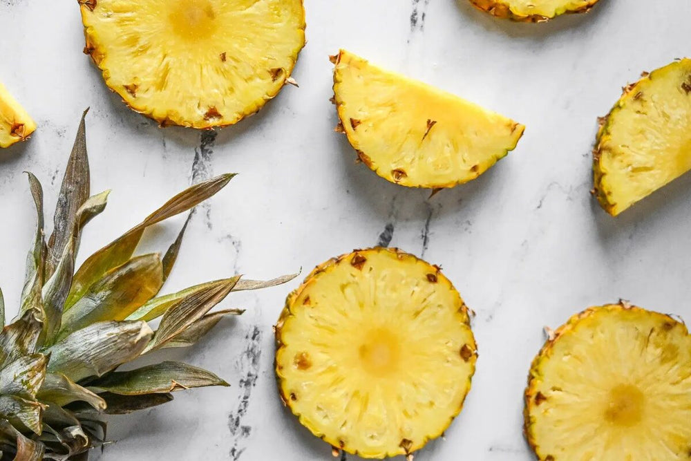 Slices of pineapple on a marble countertop.