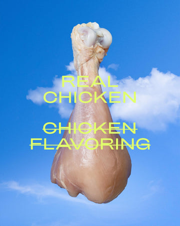 Raw chicken leg with text overlay: Real Chicken & Chicken flavoring scratched over it. 